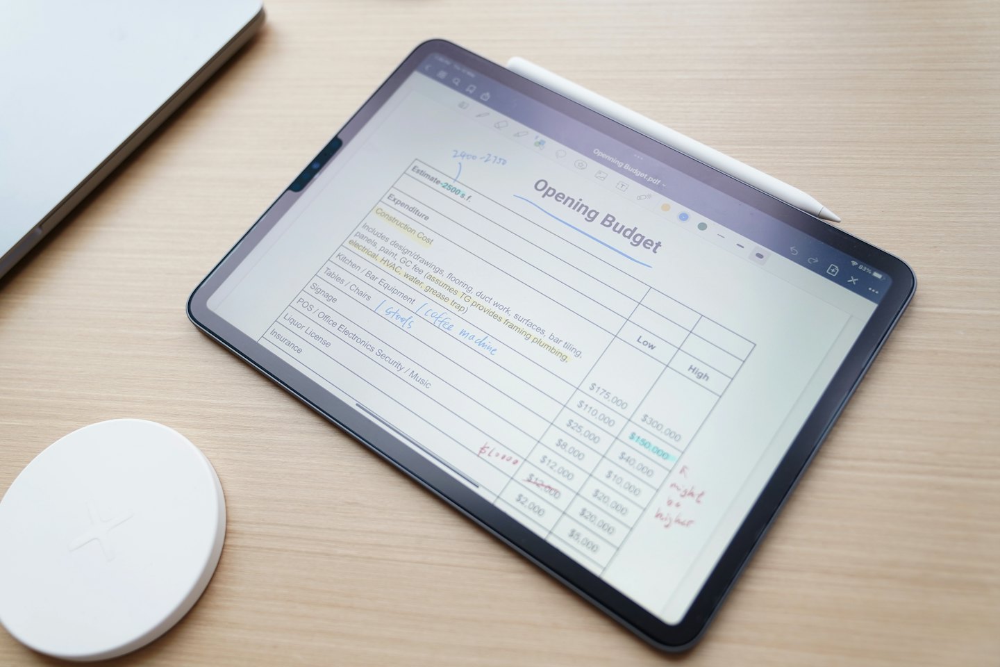 Tablet menampilkan spreadsheet anggaran digital dengan stylus di layar.
